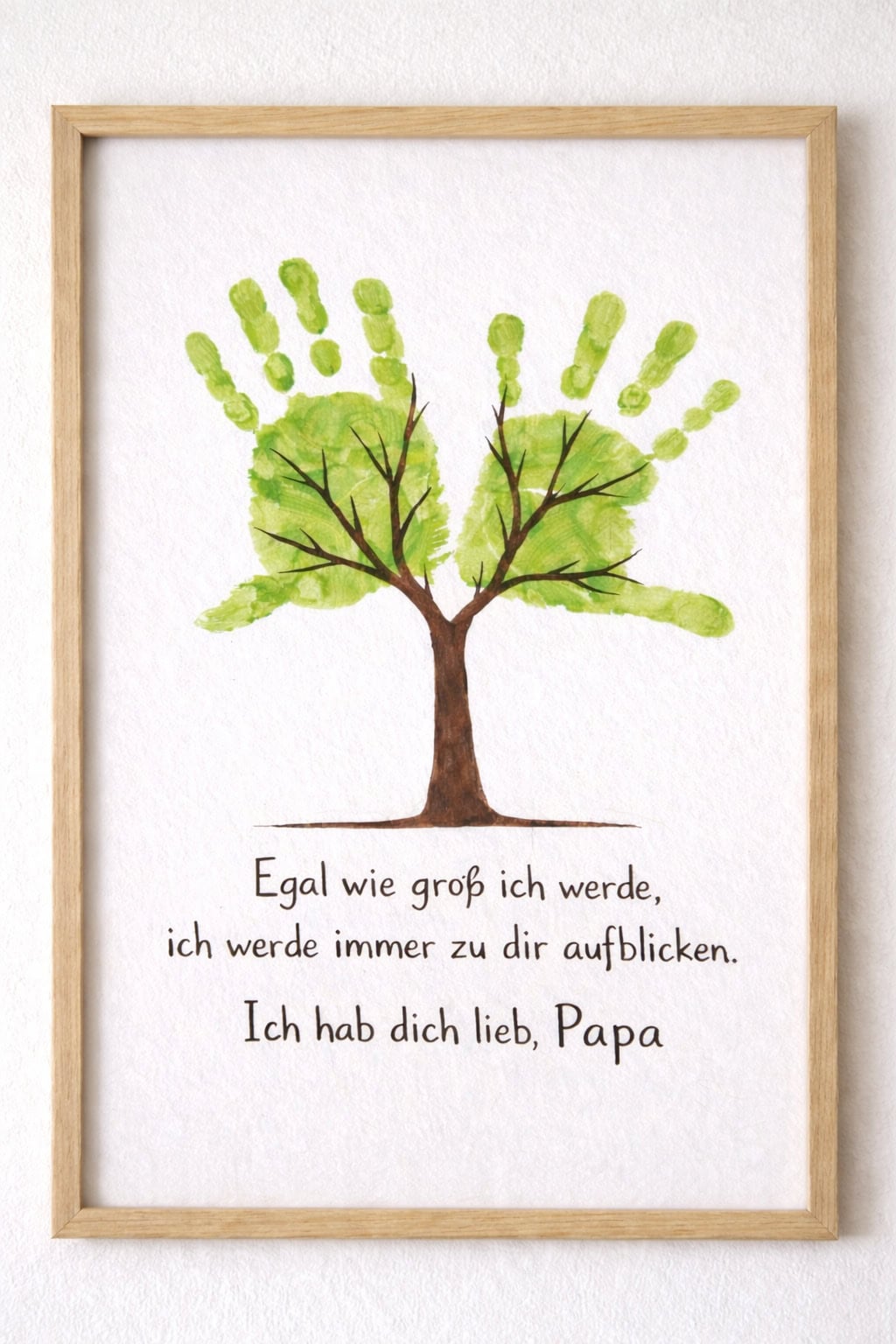 Gerahmtes Bild mit zwei grünen Handabdrücken als Baumkrone und Spruch für Papa zum Vatertag.